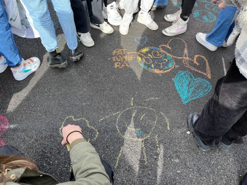 Nel corteo degli studenti del Friday For Future gli studenti scrivono messaggi con i gessetti sull'asfalto in corso Nizza
